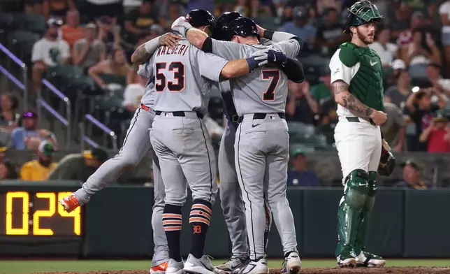 Detroit Tigers' Dillon Dingler, not shown, celebrates with Ben Malgeri (53), Kevin McGonigle (7), and Javier Báez, not shown, after hitting a grand slam during the eighth inning of a baseball game against the Athletics, Friday, July 31, 2026, in West Sacramento, Calif. (AP Photo/Sara Nevis)