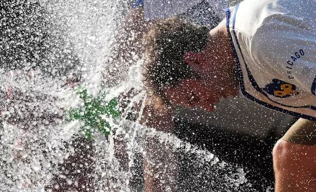 FILE - A person cools off in front of a Chicago Fire Department during a hot weather day in Chicago, June 30, 2026. (AP Photo/Nam Y. Huh, File)