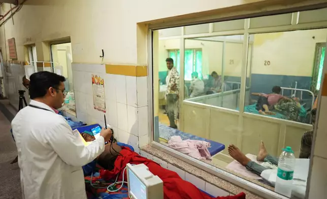 FILE - Dr. Abhishek Pranayami examines a patient suffering from a heat-related illness amid high temperatures at a district government hospital in Banda, northern Indian state of Uttar Pradesh, June 19, 2026 (AP Photo/Rajesh Kumar Singh, File)