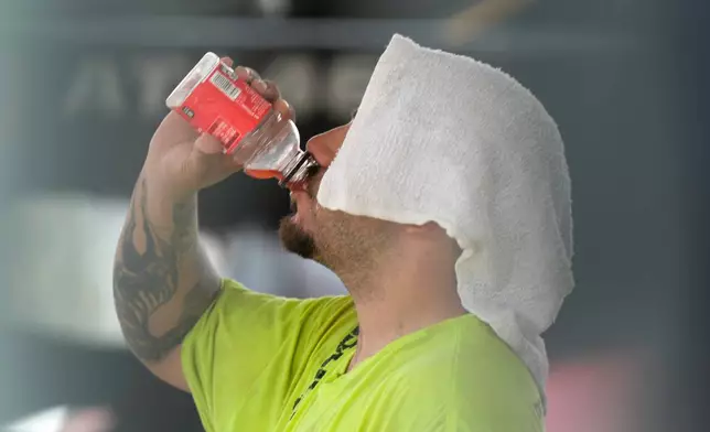 FILE - A construction worker hydrates at the Shedd Aquarium, Aug. 27, 2024, on a hot day in Chicago. (AP Photo/Charles Rex Arbogast, File)