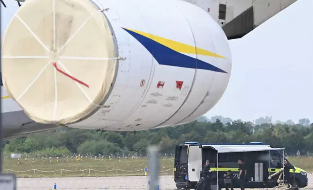 Police forensic technicians prepare to deploy an explosive-disposal robot near a Ukrainian aircraft at Leipzig/Halle Airport, in Schkeuditz, Germany, Wednesday Aug. 5, 2026, where flight operations were suspended overnight after a drone sighting was reported and another object was found near a runway. (Hendrik Schmidt/dpa via AP)