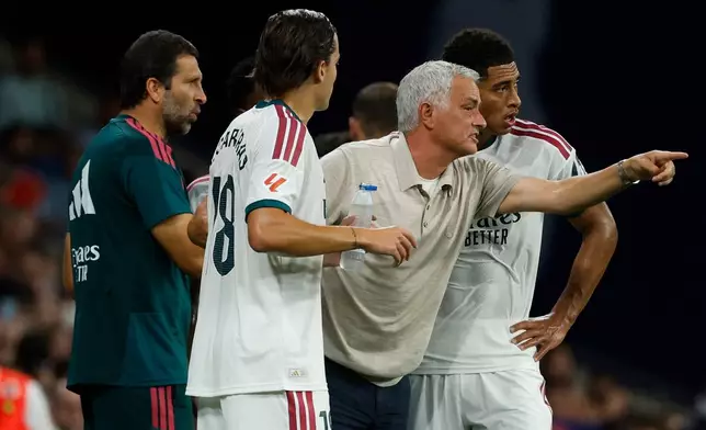 Real Madrid's head coach Jose Mourinho talks with his player Real Madrid's Jude Bellingham during a Spanish La Liga soccer match between Espanyol and Real Madrid in Barcelona, Spain, Saturday, Aug. 22, 2026. (AP Photo/Joan Monfort)