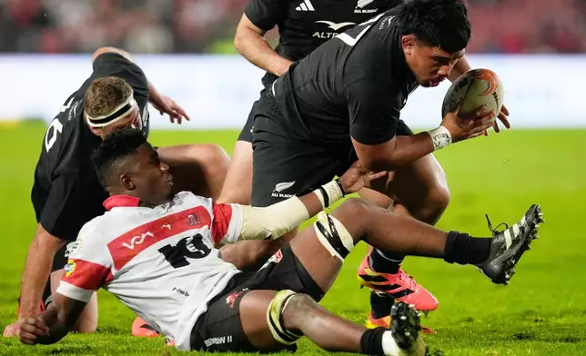 New Zealand's Ofa Tu'ungafasi, right, breaks away from Lions' Siba Mahashe during an international friendly rugby match between the Lions and New Zealand in Johannesburg, South Africa, Tuesday, Aug. 25, 2026. (AP Photo/Themba Hadebe)