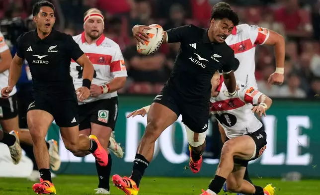 New Zealand's Emoni Narawa, front, is challenged by Lions' Nico Steyn during an international friendly rugby match between Lions and New Zealand, in Johannesburg, South Africa, Tuesday, Aug. 25, 2026. (AP Photo/Themba Hadebe)