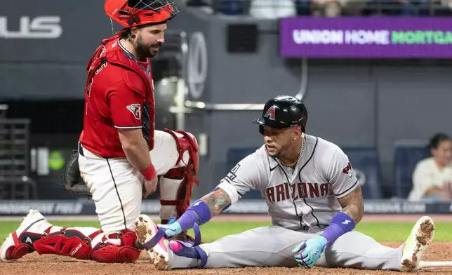 Cleveland Guardians' Austin Hedges, left, checks with Arizona Diamondbacks' Ketel Marte, right, after he was hit by a pitch from Hunter Gaddis during the seventh inning of a baseball game, Saturday, Aug. 1, 2026, in Cleveland. (AP Photo/Phil Long)