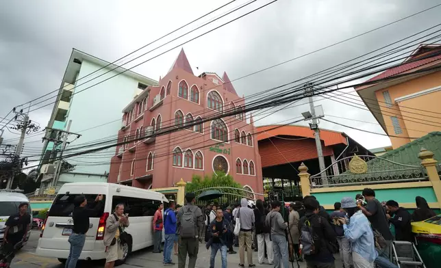 A crowd gathers outside a school where deaths and injuries were reported after a shooting in Thailand's Nonthaburi province, Friday, Aug. 7, 2026. (AP Photo/Sakchai Lalit)