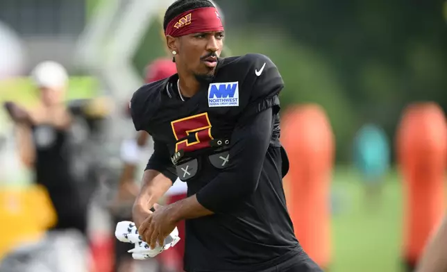 Washington Commanders quarterback Jayden Daniels works out before a joint practice with the Miami Dolphins at NFL football training camp, Wednesday, Aug. 12, 2026 in Ashburn, Va. (AP Photo/Nick Wass)