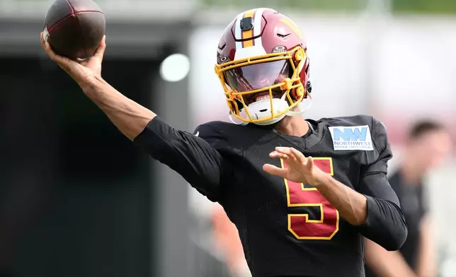 Washington Commanders quarterback Jayden Daniels works out before a joint practice with the Miami Dolphins at NFL football training camp, Wednesday, Aug. 12, 2026 in Ashburn, Va. (AP Photo/Nick Wass)