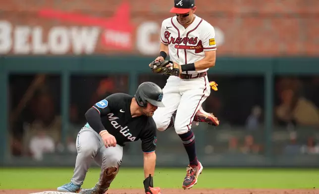 Atlanta Braves left fielder Mauricio Dubón (14) makes the tag on Miami Marlins' Jakob Marsee (87) in the third inning of a baseball game, Wednesday, Aug. 5, 2026, in Atlanta. (AP Photo/Mike Stewart)