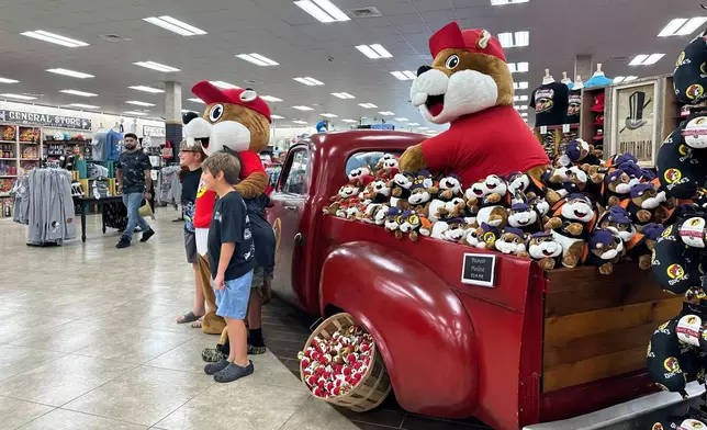 Customers at the Buc-ee's location in Huber Heights, Ohio, pose with the company's mascot on Friday, Aug. 14, 2026. (AP Photo/Julie Carr Smyth)