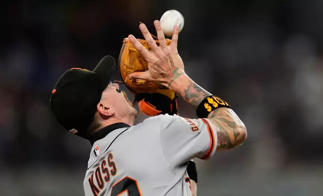 San Francisco Giants third baseman Christian Koss reaches up to catch a pop-out by Texas Rangers' Brandon Nimmo in the fifth inning a baseball game in Arlington, Texas, Tuesday, Aug. 4, 2026. (AP Photo/Tony Gutierrez)
