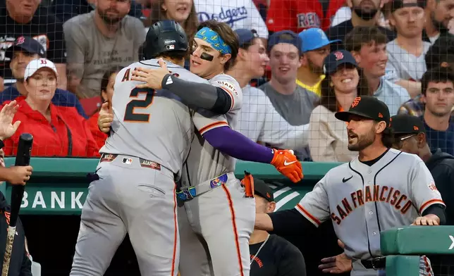 San Francisco Giants' Willy Adames (2) is congratulated at the dugout by teammate Drew Gilbert after hitting a home run off Boston Red Sox starting pitcher Patrick Sandoval during the first inning of a baseball game Saturday, Aug. 22, 2026, in Boston. (AP Photo/Mary Schwalm)