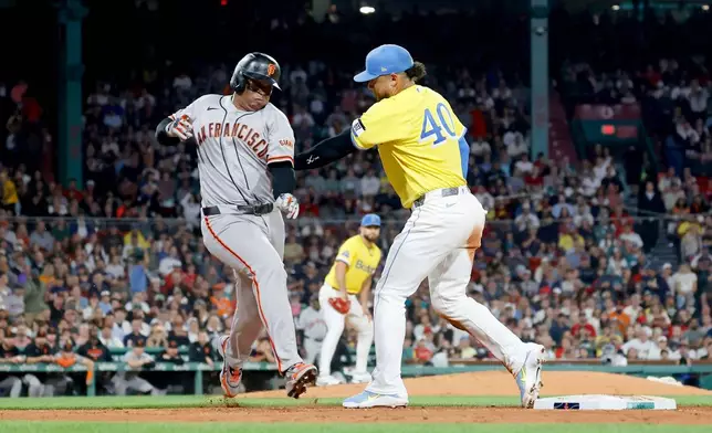 Boston Red Sox first baseman Willson Contreras (40) tags out San Francisco Giants' Rafael Devers, left, at first during the fifth inning of a baseball game Saturday, Aug. 22, 2026, in Boston. (AP Photo/Mary Schwalm)
