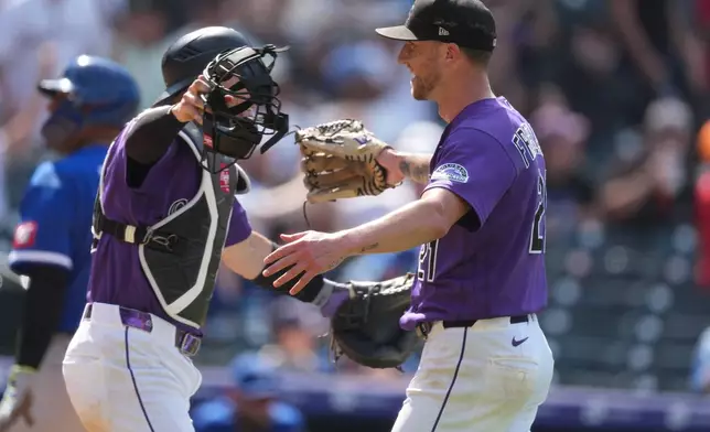 Colorado Rockies catcher Brett Sullivan, left, hugs starting pitcher Kyle Freeland, right, after Kansas City Royals' Tyler Tolbert flew out to end a baseball game Sunday, Aug. 2, 2026, in Denver. (AP Photo/David Zalubowski)
