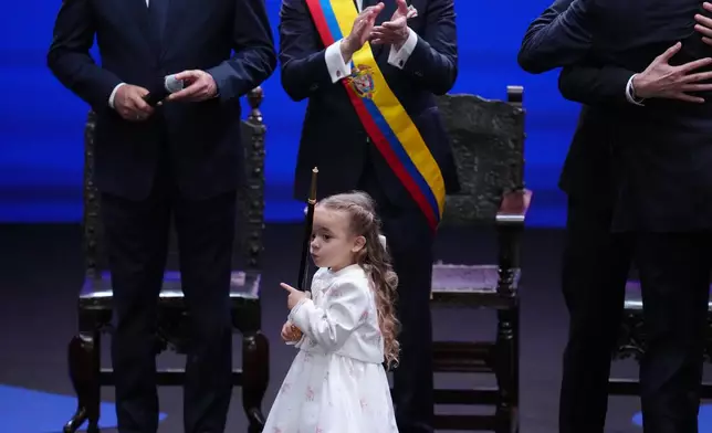 Colombia's President Abelardo de la Espriella's daughter, Francesca, takes the ceremonial staff after he took the oath of office in Cali, Colombia, Friday, Aug. 7, 2026. (AP Photo/Matias Delacroix)
