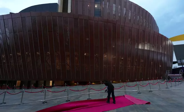 A worker lays out the red carpet at the Universidad Santiago de Cali arena, where the inauguration of President-elect Abelardo de la Espriella will take place, in Cali, Colombia, Thursday, Aug. 6, 2026. (AP Photo/Matias Delacroix)