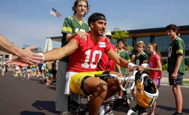 Green Bay Packers quarterback Jordan Love (10) rides a bike to practice at the team's NFL football training camp, Thursday, July 30, 2026, in Green Bay, Wis. (AP Photo/Matt Ludtke)