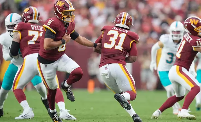 Washington Commanders quarterback Marcus Mariota (8) hands the ball to running back Kaytron Allen (31) during the first half of an NFL preseason football game, Friday, Aug. 14, 2026, in Landover, MD. (AP Photo/Manuel Balce Ceneta)