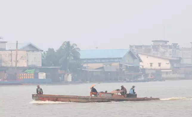 A boat cruises on the Kapuas River as haze from wildfires blanket the city of Pontianak, West Kalimantan, Indonesia, Friday, Aug. 21, 2026. (AP Photo/Stefanus Taman)