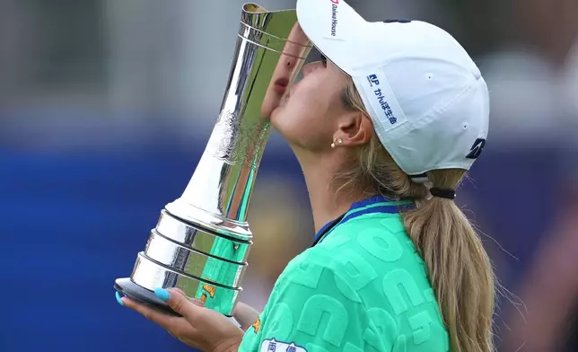 Shiho Kuwaki, of Japan, kisses the trophy after winning the Women's British Open golf championship in Lytham St Annes, England, Sunday, Aug. 2, 2026. (AP Photo/Jon Super)