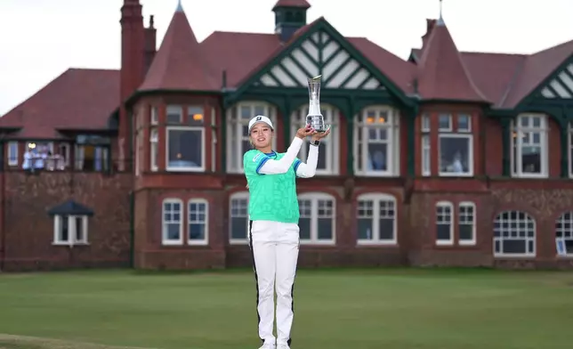 Shiho Kuwaki, of Japan, holds up the trophy after winning the Women's British Open golf championship in Lytham St Annes, England, Sunday, Aug. 2, 2026. (AP Photo/Jon Super)