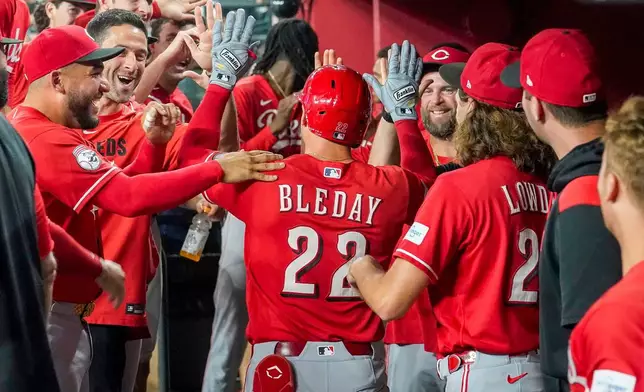 Cincinnati Reds' JJ Bleday, center, gets high-fives from teammates after hitting for the cycle during the sixth inning of a baseball game against the Arizona Diamondbacks, Saturday, Aug. 22, 2026, in Phoenix. (AP Photo/Darryl Webb)