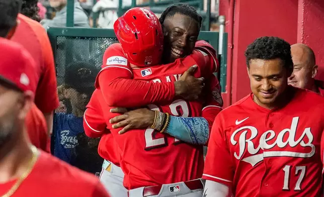 Cincinnati Reds' Elly De La Cruz, center right, hugs JJ Bleday, after Bleday hit for the cycle during the sixth inning of a baseball game against the Arizona Diamondbacks, Saturday, Aug. 22, 2026, in Phoenix. (AP Photo/Darryl Webb)