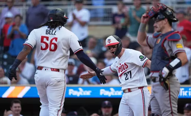 Minnesota Twins' Josh Bell (56) is greeted by Ryan Jeffers (27) while crossing home plate after hitting a 2-run home run during the first inning of a baseball game against the Atlanta Braves in Minneapolis, Tuesday, Aug. 18, 2026. (AP Photo/Abbie Parr)