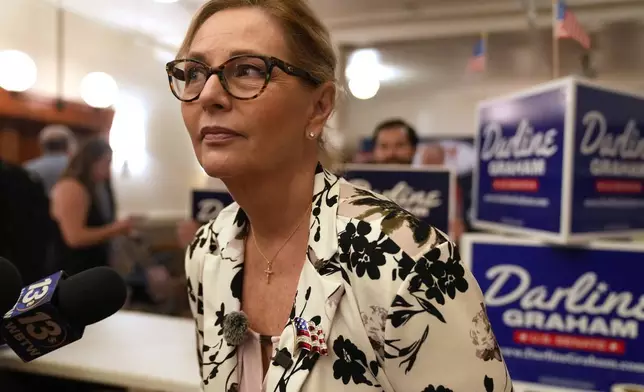 Sen. Darline Graham, R-S.C., leans over to hear a reporter's question following at a candidate event for hopefuls vying in a special Republican primary to replace her late brother Sen. Lindsey Graham, R-S.C., on November ballots, Saturday, Aug. 8, 2026, in Florence, S.C. (AP Photo/Meg Kinnard)