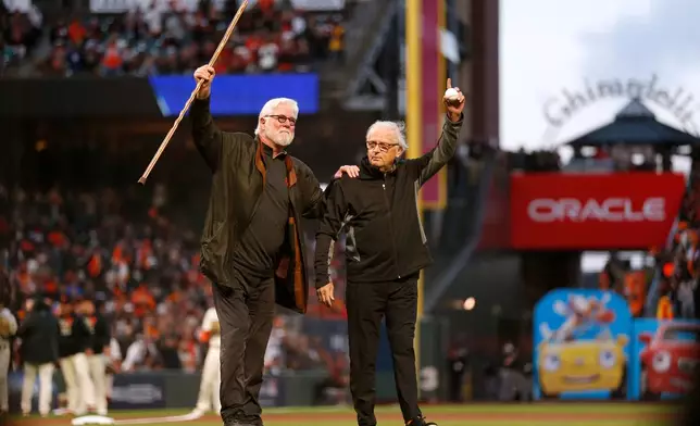 FILE - San Francisco Giants broadcasters Mike Krukow, left, and Duane Kuiper walk on the field before Game 1 of a baseball National League Division Series between the Giants and the Los Angeles Dodgers, Oct. 8, 2021, in San Francisco. (AP Photo/Jed Jacobsohn, File)