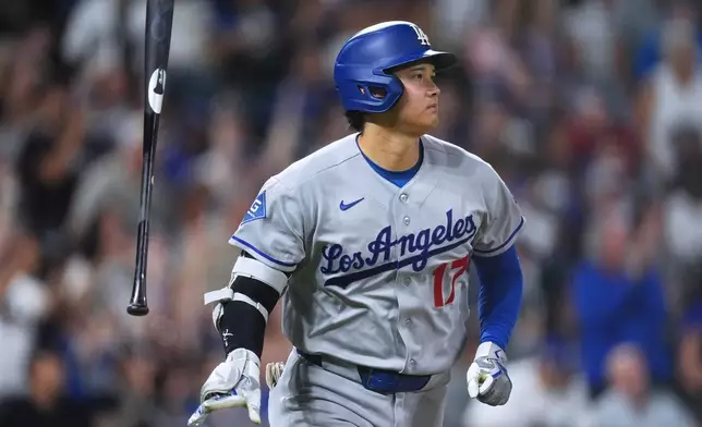 Los Angeles Dodgers' Shohei Ohtani tosses his bat as he heads up the first base line after hitting a two-run home run off Colorado Rockies relief pitcher Juan Mejia in the sixth inning of a baseball game Monday, Aug. 17, 2026, in Denver. (AP Photo/David Zalubowski)
