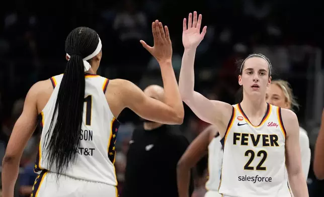 Indiana Fever guard Caitlin Clark (22) high-fives teammates in the overtime during an WNBA basketball game against the Atlanta Dream Sunday, Aug. 16, 2026, in Atlanta. (AP Photo/Brynn Anderson)