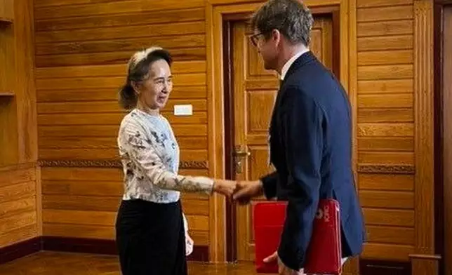 In this photo released by Myanmar President Office on Monday, Aug. 3, 2026, Myanmar's ousted leader Aung San Suu Kyi, left, shakes hands with Arnaud de Baecque, resident representative of the International Committee of the Red Cross, during their meeting in Naypyitaw, Myanmar. (Myanmar President Office via AP)
