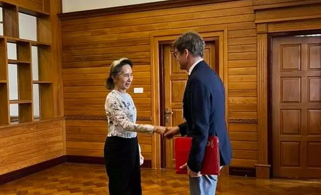 In this photo released by Myanmar President Office on Monday, Aug. 3, 2026, Myanmar's ousted leader Aung San Suu Kyi, left, shakes hands with Arnaud de Baecque, resident representative of the International Committee of the Red Cross, during their meeting in Naypyitaw, Myanmar. (Myanmar President Office via AP)