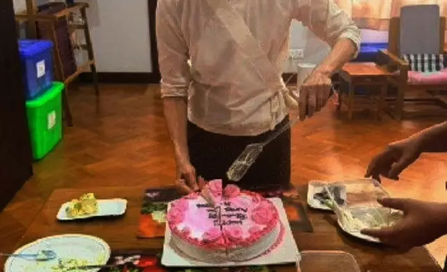 In this photo released by Myanmar President Office on Monday, Aug. 3, 2026, Myanmar ousted leader Aung San Suu Kyi cuts a birthday cake during her meeting with Arnaud de Baecque, resident representative of the International Committee of the Red Cross, in Naypyitaw, Myanmar. (Myanmar President Office via AP)