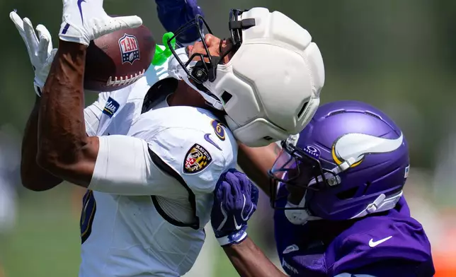 Baltimore Ravens wide receiver Ja'Kobi Lane, left, makes a contested catch in front of Minnesota Vikings cornerback Charles Demmings (20) during a joint NFL football practice, Wednesday, Aug 19, 2026, in Eagan, Minn. (Alex Kormann/Minnesota Star Tribune via AP)