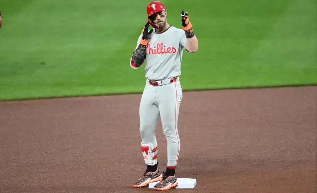 Philadelphia Phillies' Bryce Harper gestures at second base after hitting a ground rule double during the fourth inning of a baseball game against the Baltimore Orioles, Saturday, Aug. 1, 2026, in Baltimore. (AP Photo/Nick Wass)