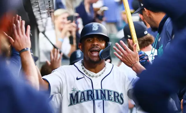 Seattle Mariners' Julio Rodríguez celebrates in the dugout after hitting a three-run home run in the sixth inning of a baseball game against the Detroit Tigers, Wednesday, Aug. 5, 2026, in Seattle. (AP Photo/Kevin Ng)