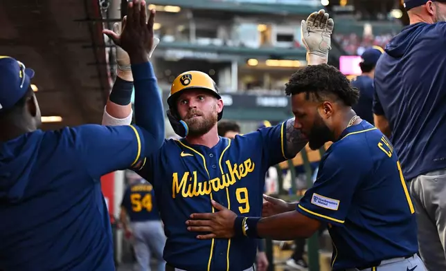 Milwaukee Brewers' Jake Bauers (9)is greeted by teammates after hitting a home run during the fourth inning of a baseball game against the Los Angeles Angels, Saturday, Aug. 1, 2026, in Anaheim, Calif. (AP Photo/William Liang)