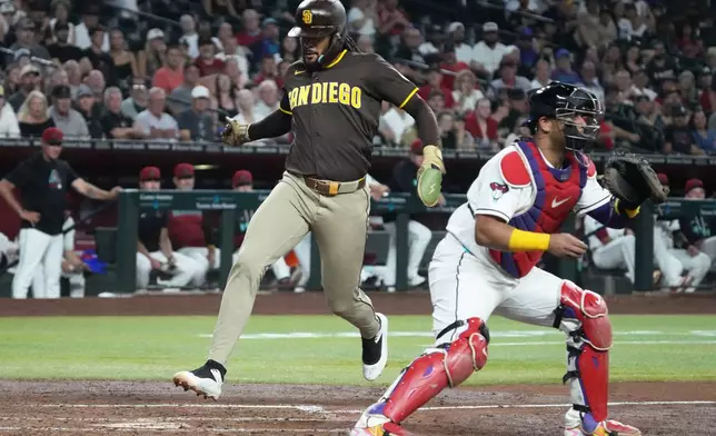 San Diego Padres' Fernando Tatis Jr., left, scores against the Arizona Diamondbacks on a ball hit by Ty France in the third inning of a baseball game, Thursday, Aug 6, 2026, in Phoenix. (AP Photo/Rick Scuteri)