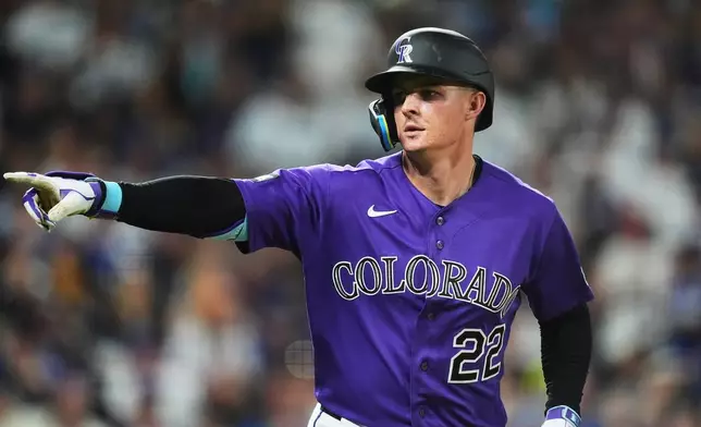 Colorado Rockies' Mickey Moniak gestures to the dugout as he heads up the first-base line after connecting for a two-run home run off Los Angeles Dodgers relief pitcher Alex Vesia in the seventh inning of a baseball game Wednesday, Aug. 19, 2026, in Denver. (AP Photo/David Zalubowski)