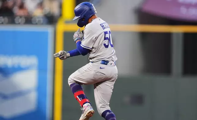 Los Angeles Dodgers' Mookie Betts jumps as he circles the bases after hitting a solo home run off Colorado Rockies starting pitcher Kyle Freeland in the fourth inning of a baseball game Wednesday, Aug. 19, 2026, in Denver. (AP Photo/David Zalubowski)
