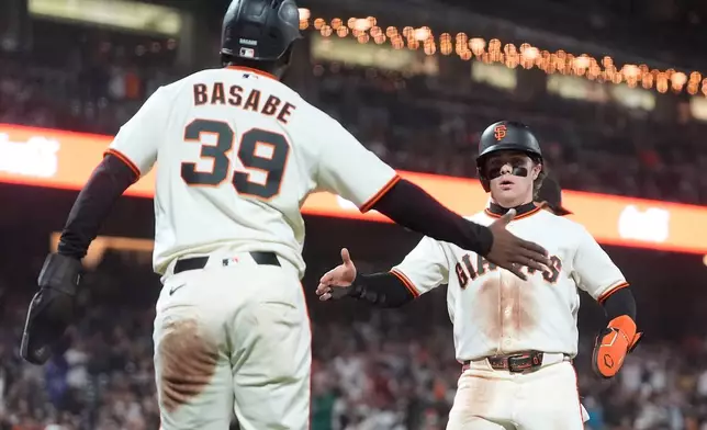 San Francisco Giants' Osleivis Basabe (39) celebrates with Drew Gilbert after both scored on Bryce Eldridge's two-run single against the Arizona Diamondbacks during the fifth inning of the second baseball game of a doubleheader, Saturday, Aug. 29, 2026, in San Francisco. (AP Photo/Jeff Chiu)