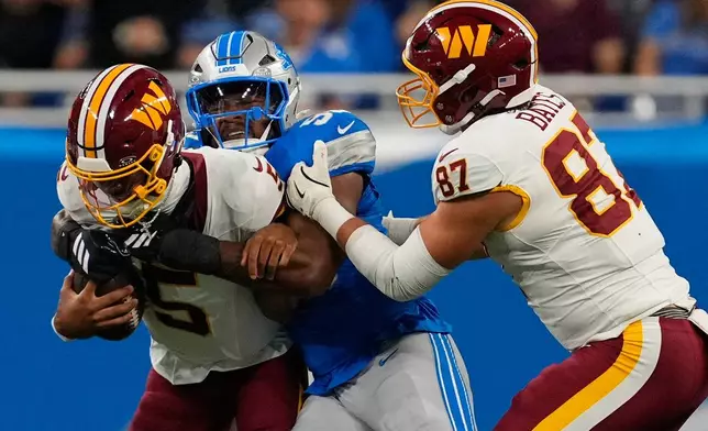 Detroit Lions defensive end D.J. Wonnum (98) sacks Washington Commanders quarterback Jayden Daniels (5) during a preseason NFL football game, Saturday, Aug. 22, 2026, in Detroit. (AP Photo/Paul Sancya)