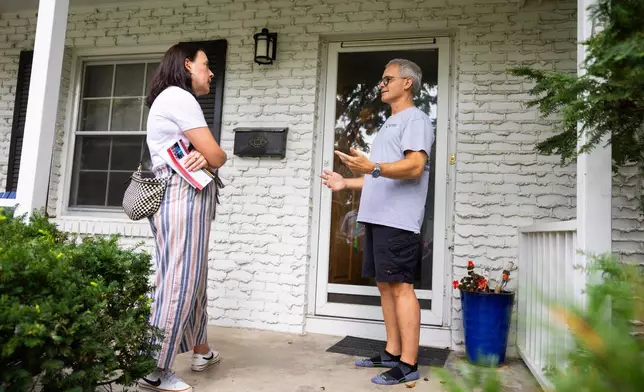 Denise Powell, left, the Democratic candidate for the House of Representatives in Nebraska's second congressional district, chats with Andy Maxwell on his doorstep in Omaha, Neb., Saturday, Aug. 15, 2026. (AP Photo/Rebecca S. Gratz)