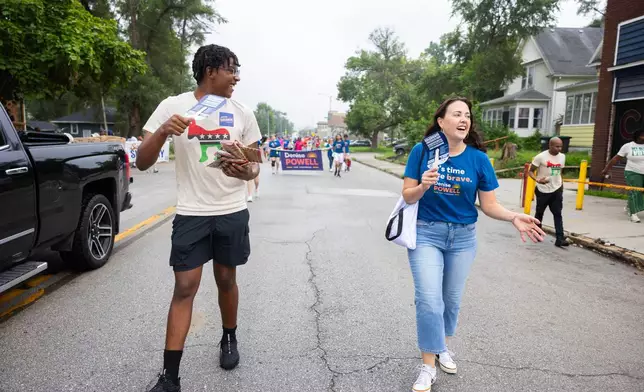 Lailend Duncan, 17, left, secretary of the Nebraska Young Democrats, chats with Denise Powell, the Democratic candidate for the House of Representatives in Nebraska's second congressional district, while walking in a Juneteenth Parade in Omaha, Neb., Saturday, Aug. 15, 2026. (AP Photo/Rebecca S. Gratz)