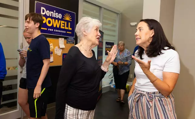 Kathy Bigsby Moore, left center, chats with Denise Powell, the Democratic candidate for the House of Representatives in Nebraska's second congressional district, during an event celebrating Powell's new campaign office in Omaha, Neb., Saturday, Aug. 15, 2026. (AP Photo/Rebecca S. Gratz)