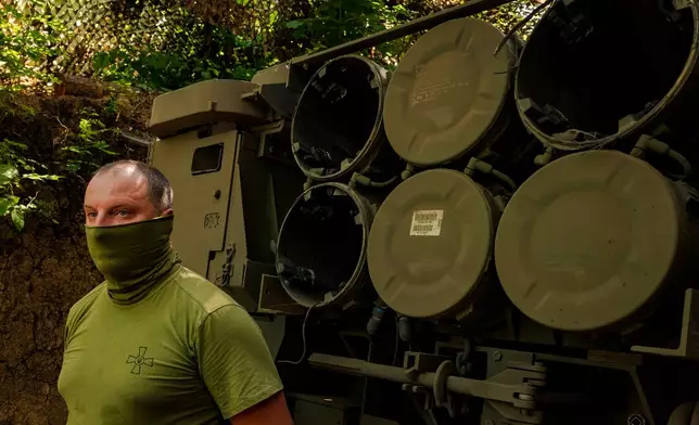 A member of a Ukrainian HIMARS crew, attached to the 148th brigade, stands next to launch tubes on the front line in eastern Ukraine, before firing rockets at Russian positions, Saturday, Aug. 8, 2026. (AP Photo/Dan Bashakov)