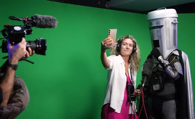 A journalist takes a selfie with Count Binface after he is interviewed at a studio in London ahead of the Clacton by-election, Wednesday, July 29, 2026. (AP Photo/Kirsty Wigglesworth)