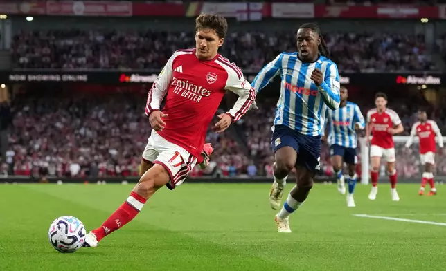 Arsenal's Christos Tzolis runs with the ball followed by Coventry City's Brandon Thomas-Asante during the English Premier League soccer match between Arsenal and Coventry City in London, Friday, Aug. 21, 2026. (AP Photo/Kirsty Wigglesworth)